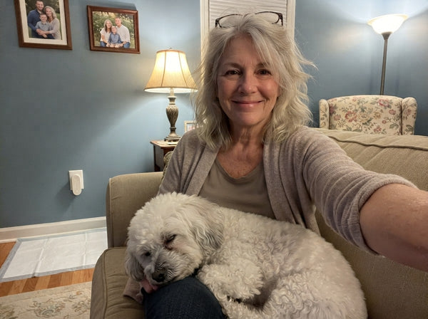 Owner selfie on the sofa with her senior Bichon Frise, Odopaw plugged into the living room wall