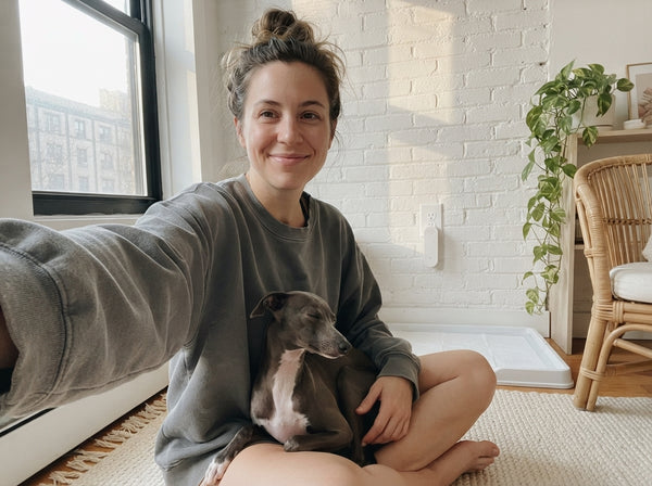 Owner selfie with her Italian Greyhound in a studio apartment, Odopaw plugged in above the pee pad